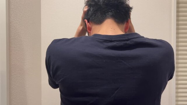 ショックで頭を抱える男性