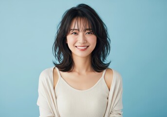 Fototapeta premium Beautiful Young Asian Woman Smiling Confidently Against a Light Blue Background - Portrait of a Happy Japanese Lady