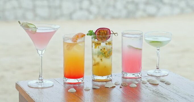 Tropical cocktails standing on wooden table, sandy beach background with seashells, summer resort bar menu advertisement, luxury travel hospitality marketing