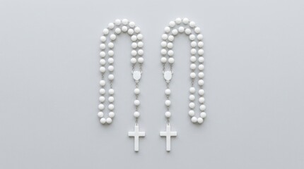 Fototapeta premium Two White Rosaries Arranged Side by Side on a Light Purple Background.
