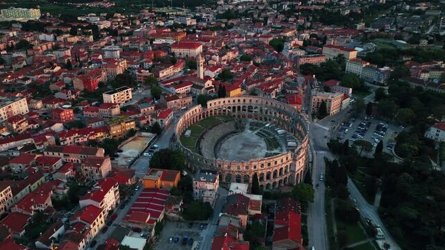 Cinematic aerial drone footage of Pula featuring historic architecture, Adriatic coastline, marina, and Mediterranean atmosphere. Scenic coastal views and ancient Roman heritage .