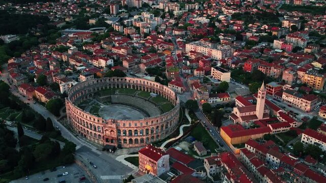 Cinematic aerial drone footage of Pula featuring historic architecture, Adriatic coastline, marina, and Mediterranean atmosphere. Scenic coastal views and ancient Roman heritage .