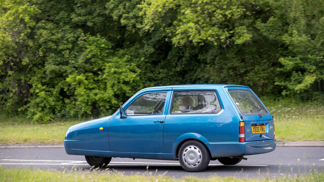 Milton Keynes,Bucks,UK - May 21st 2026:  2001 blue Reliant Robin 3 wheel classic car driving on a British road