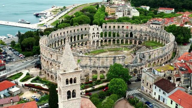 Cinematic aerial drone footage of Pula featuring historic architecture, Adriatic coastline, marina, and Mediterranean atmosphere. Scenic coastal views and ancient Roman heritage .