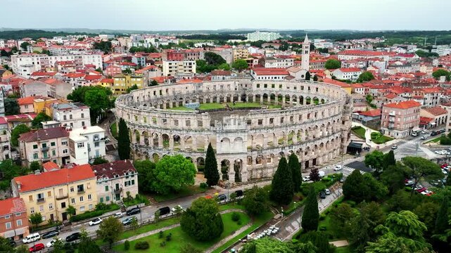 Cinematic aerial drone footage of Pula featuring historic architecture, Adriatic coastline, marina, and Mediterranean atmosphere. Scenic coastal views and ancient Roman heritage .