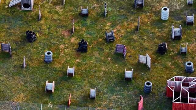 Outdoor paintball or airsoft arena with various obstacles in top down aerial perspective