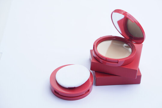 Elegant compact powder foundation with soft applicator puff and mirror in stylish pink packaging, arranged on a clean background. Beauty makeup product concept for skincare, cosmetics, and feminine 