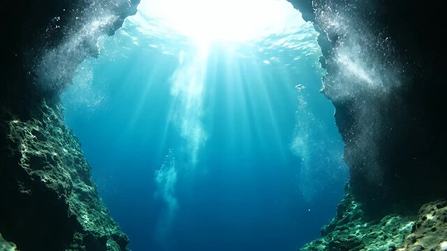 Underwater cave with sunlit beams of light shining through