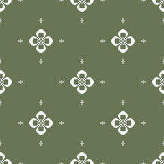 Minimal floral geometric motif with small diamond accents arranged on a muted olive green background. Seamless ethnic-inspired textile pattern with balanced spacing. © Prayma
