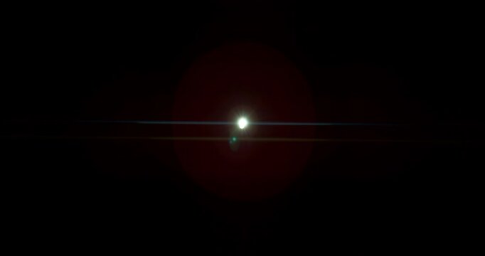 Slow motion of lens flare isolated on black background. Anamorphic lens. Cinematic glowing light overlay with optical streaks and rays for VFX compositing and transitions.