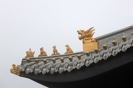 Chinese temple flying eave with geometric patterns and ridge beasts in gold colour at Peak of Mount Emei, Sichuan Province of China