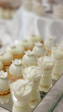 Close-up of professional catering service arranging mini trifles at a wedding buffet