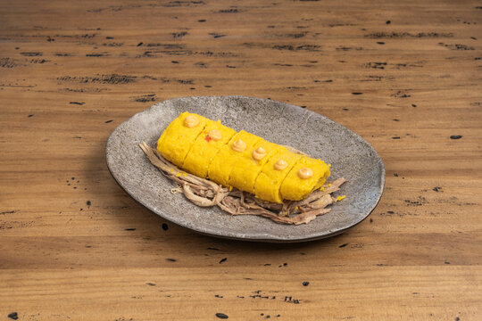 Traditional Peruvian tamale wrapped in bijao leaves, with a soft and moist yellow corn masa,