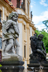 Naklejka premium Stone cherub statues by historic palace in garden