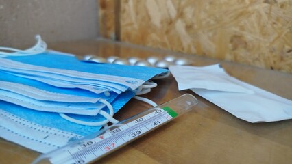 Medical flat lay with protective mask, gloves, thermometer and smartphone displaying hantavirus warning alert. Healthcare, virus prevention and public health concept.