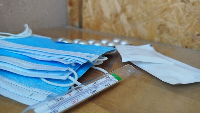 Medical flat lay with protective mask, gloves, thermometer and smartphone displaying hantavirus warning alert. Healthcare, virus prevention and public health concept.
