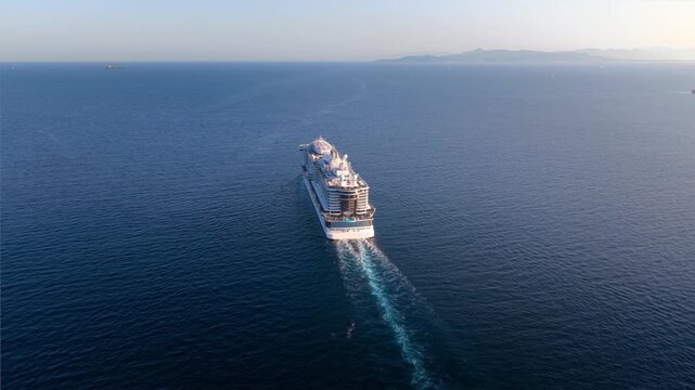 High aerial view of a cruise ship sailing over blue ocean into the sunset with copy space as a concept for travel and vacation