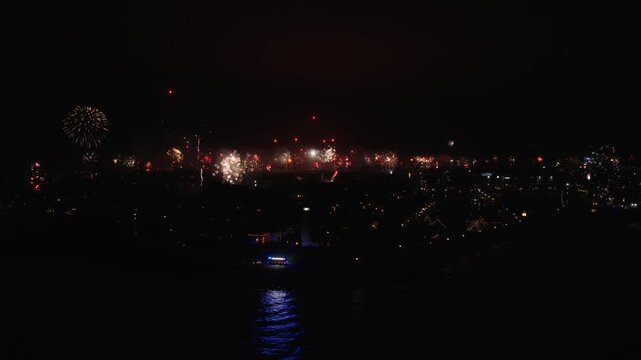 Fireworks over the Dutch town of Urk in the Netherlands, with the traditional red emergency flares from the fishing vessels being lid.