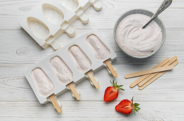 Obraz premium Preparing homemade strawberry popsicles in silicone molds