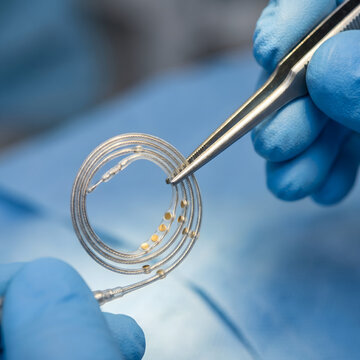 Surgeon holding cochlear implant electrode array with forceps
