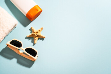 Naklejka premium Sunglasses, sunscreen and sea shell with sunny shadows.
