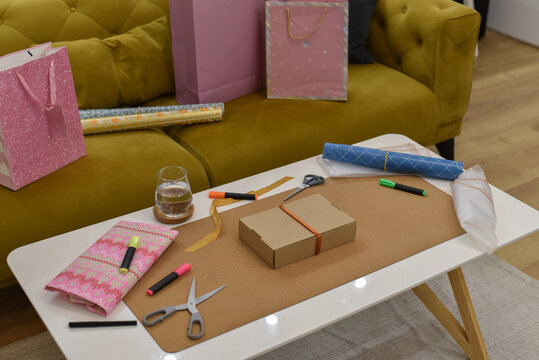 Gift wrapping supplies on white coffee table