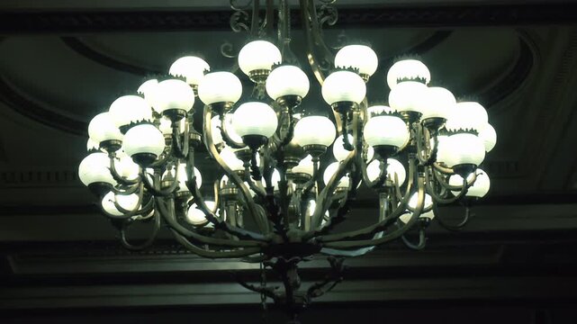 Slow Zoom In to Large Vintage Chandelier Hanging from Dark Ceiling - 4K