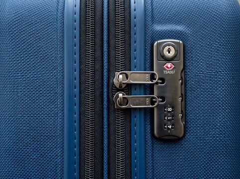 Built-in three-digit combination lock on a blue textured hard-shell travel suitcase