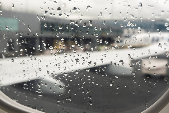 Newcastle-upon-Tyne, United Kingdom - May,13, 2026: Raindrops on airplane window before flight - moody travel scene in Newcastle