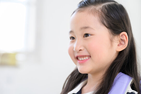 ランドセルを背負って笑顔の日本人の女の子