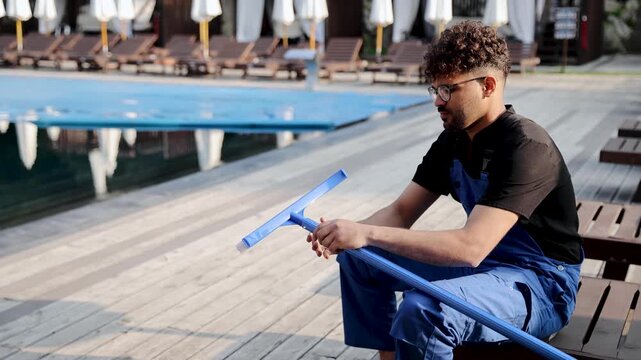 Person preparing a pool brush for swimming pool cleaning, ensuring hygiene and professional maintenance outdoors