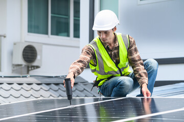 Asian Male Technician Installing Solar Panels on Rooftop Using Electric Screwdriver in Safety Gear © Prathankarnpap
