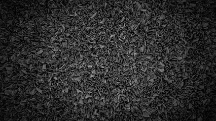 Fototapeta premium Texture of crumpled black paper fills the space with a detailed pattern of folds and creases under soft lighting