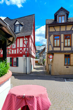 Historic half timbered houses and narrow old town alley beneath blue sky in Eltville am Rhein