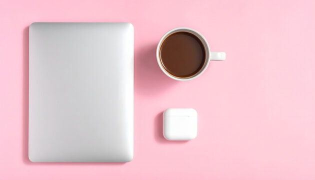 Computadora port&aacute;til cerrada con taza de caf&eacute; y auriculares sobre fondo rosa paste