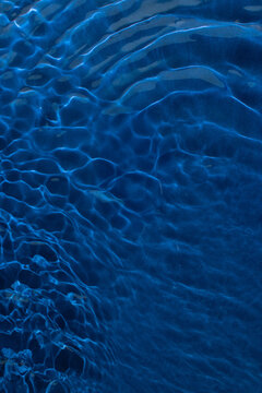 Dark deep blue water ripples background. The ocean colorful summer inspiration.