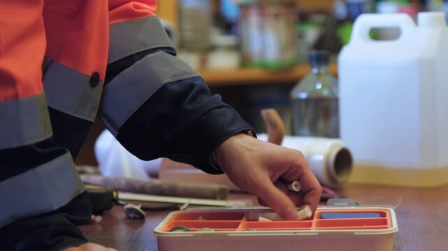 Worker prepares tools and materials in a workshop to begin a new task at the start of the day in a busy environment