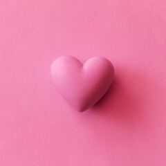 Obraz premium pink volumetric heart on plain background. Monochrome background with copy space for Valentine's Day and holiday of love.