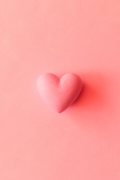 pink volumetric heart on plain background. Monochrome background with copy space for Valentine's Day and holiday of love.