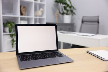 Fototapeta premium Laptop and notebook on wooden desk in office, closeup