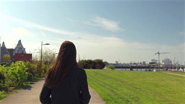 Woman walking along waterfront path in Dunkirk France