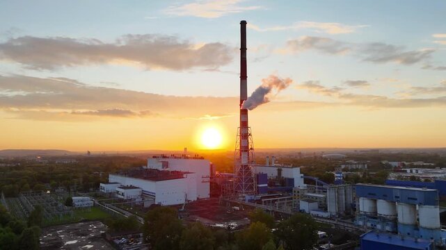 Industrial power plant with smokestack emits steam against sunset backdrop, showcasing gradual light change and landscape details in the foreground and background across three frames