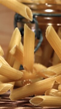 Penne pasta falling on a wooden table. Filmed on a high-speed camera at 1000 fps. High quality FullHD footage