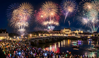 Obraz premium Fireworks Celebration Over a Historic Riverfront and Stone Bridge
