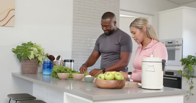 African American couple chopping celery at kitchen island after picking produce, preparing salad