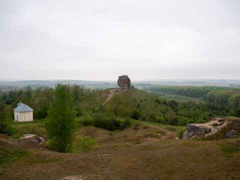 Wide landscape with Devils Stone in distance and small chapel on green hill