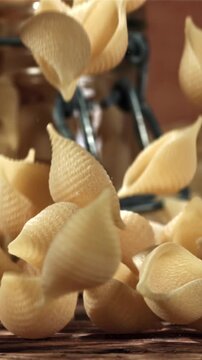 Dry pasta falls on a wooden table. Filmed on a high-speed camera at 1000 fps. High quality FullHD footage