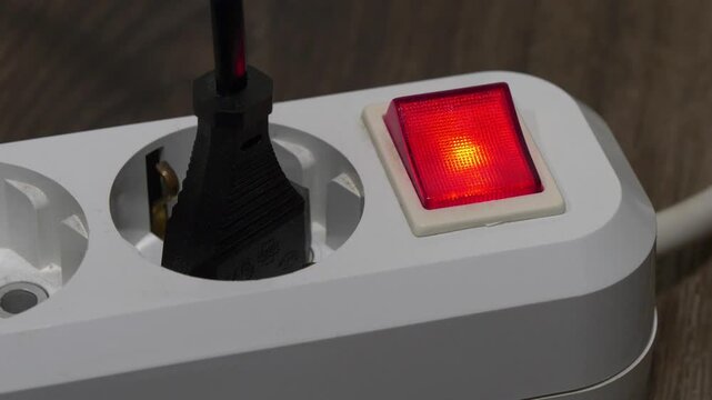 Plug is inserted into the white electric socket with red power indicator