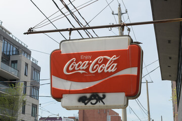 Naklejka premium wall mounted projecting vintage Enjoy Coca-Cola sign, close-up in Toronto (ghost sign outside Cebon Variety, 672 Kingston Rd)
