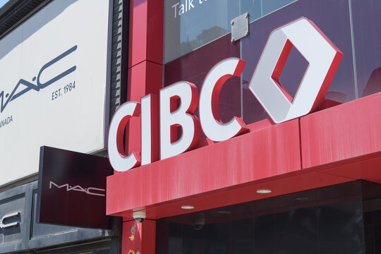 exterior building facade and sign of CIBC bank branch located at 364 Queen St W (and defocused sign of MAC Cosmetics), Toronto